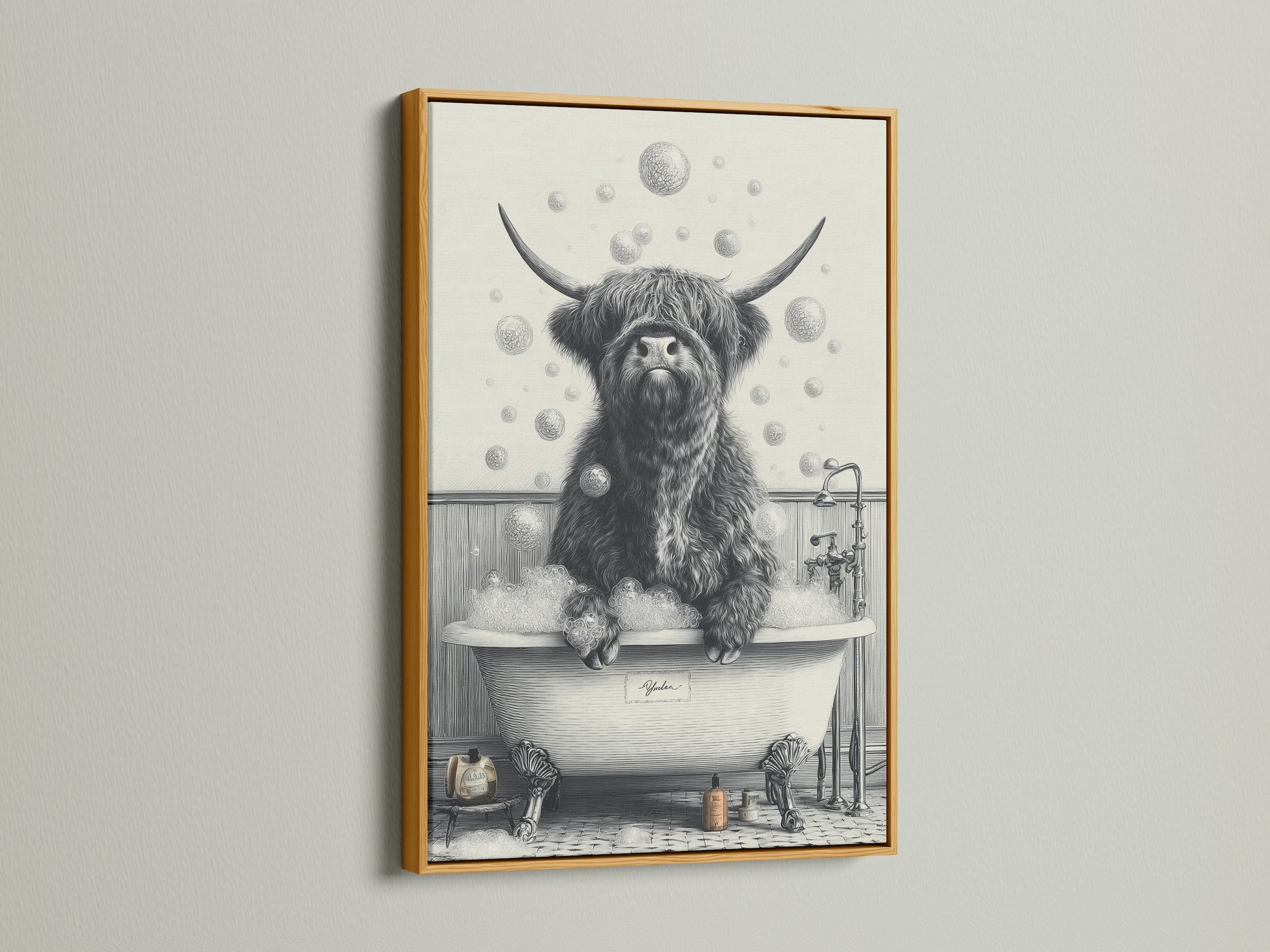 The Highland Cow in Tub artwork is highlighted by a gold frame. The artwork features a black and white Scottish cow enjoying a bubble bath. This is a charming piece of animal canvas art for your farmhouse bathroom decor.