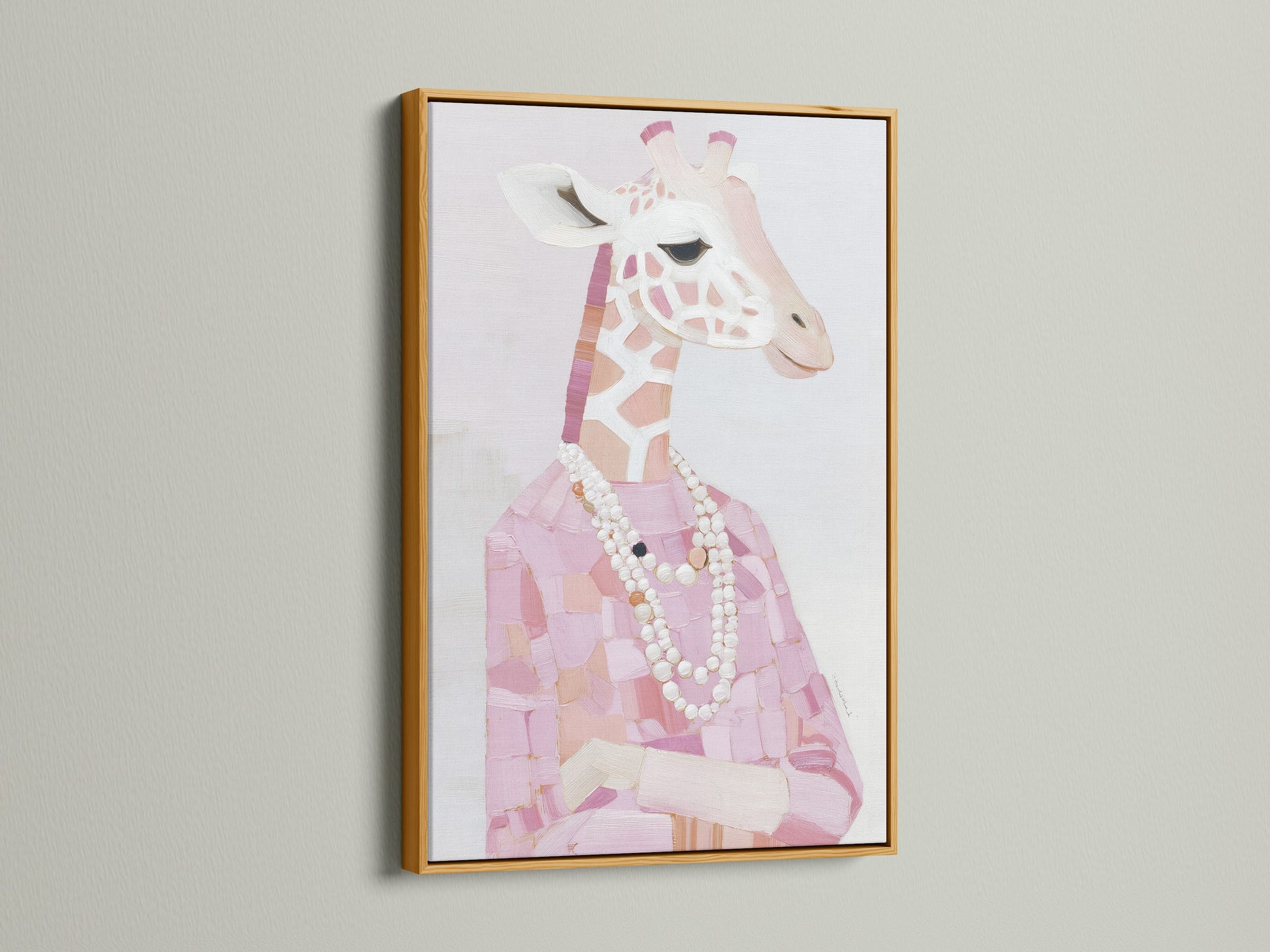 A gold frame displays a Giraffe Portrait Canvas Print. The pink animal print adds a touch of elegance. Fashion giraffe art is adorned with a pearl necklace. Gold frame complements the blush pink art. This stylish animal art is luxurious and refined.