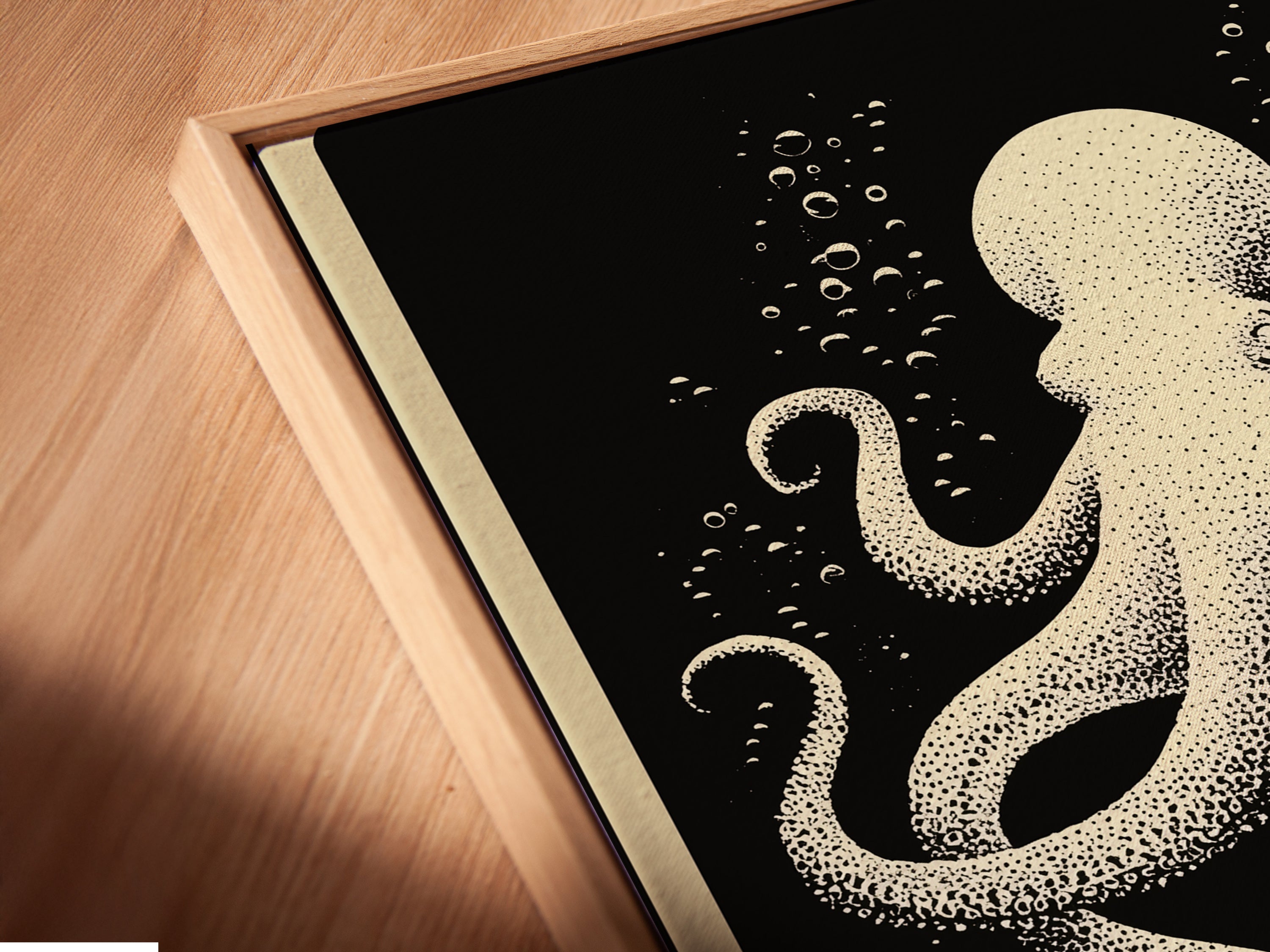 Angled close up of a canvas print in floating frame. The octopus canvas print is nautical wall art. This piece shows coral reef art for coastal home decor. The floating frame gives a gallery look to this ocean creature artwork.