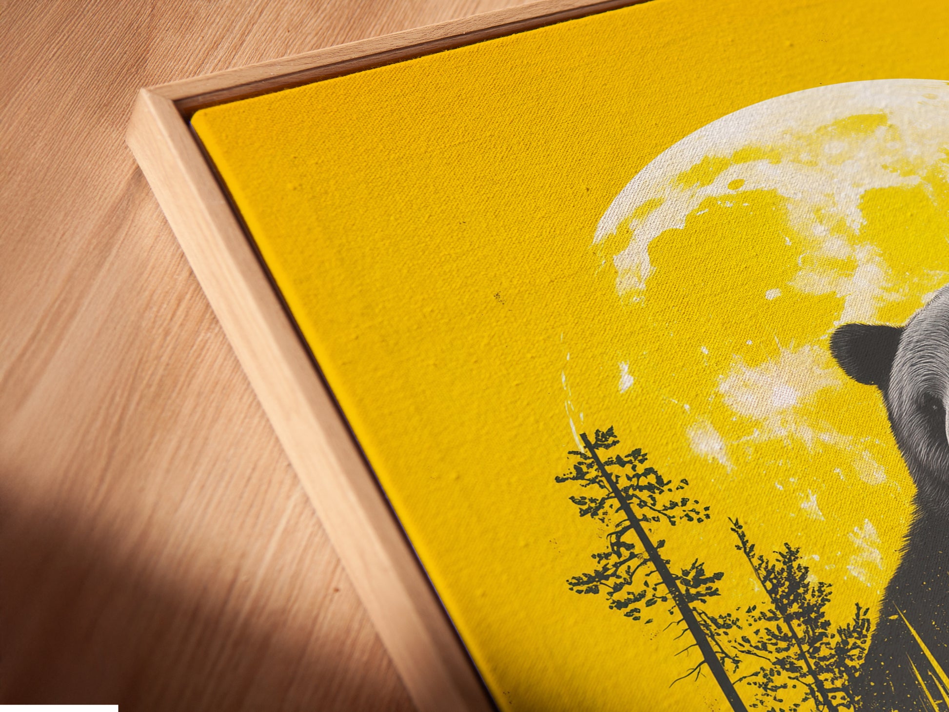 This is a close-up angled view of a canvas print in a floating frame. The artwork is the Bear and Canoe piece. The print adds depth and dimension. It is ideal for those seeking unique wall art solutions. It brings a gallery-quality feel to any room. Perfect for cabins and rustic homes.