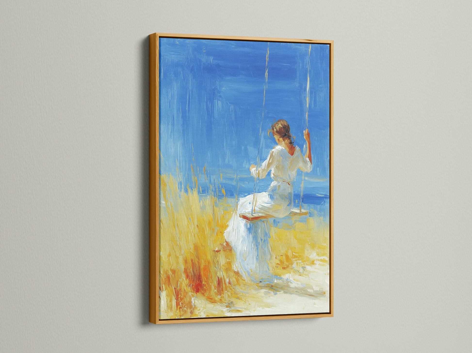 Artwork with a gold frame is displayed. The artwork features a woman in a white dress sitting on a swing. The background shows a blue sea and yellow field. The gold frame adds a touch of elegance and luxury. It enhances the artwork's visual appeal.