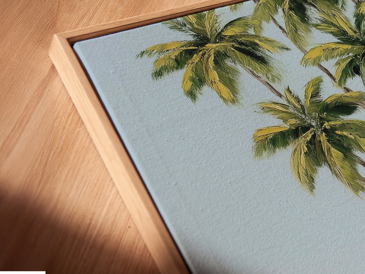 Close up of a canvas print in a floating frame. The tropical beach artwork features palm trees and a boat on the beach. The floating frame gives the art a modern look. Ideal for adding a coastal touch to your decor.