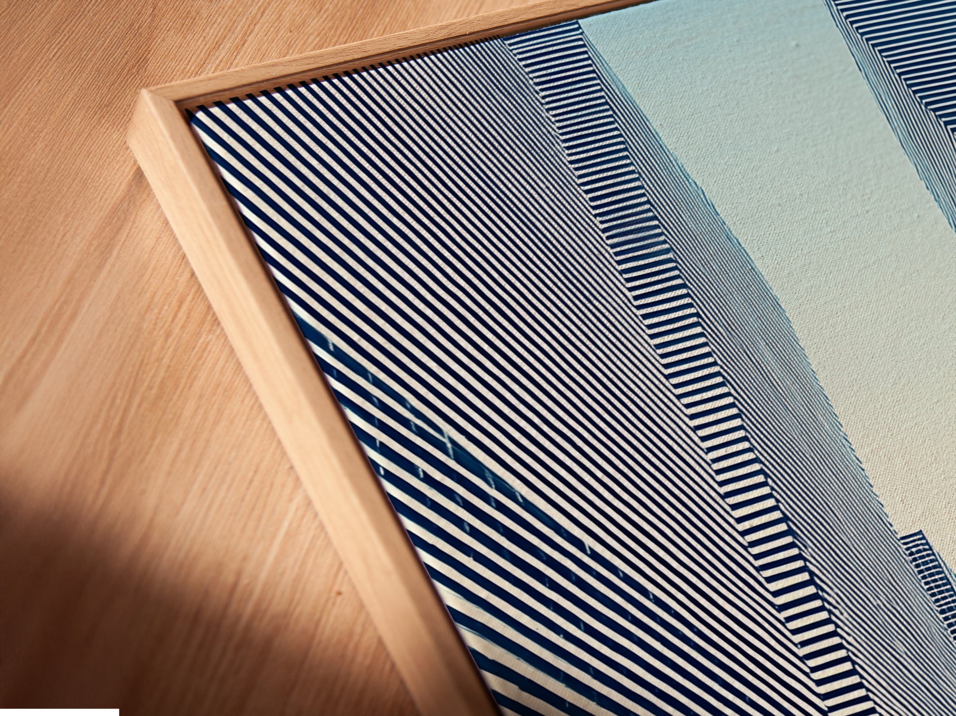 A close-up angled view shows a canvas print in a floating frame. The Cityscape Optical Illusion artwork is modern and eye-catching. The black and white art enhances any room's decor. Perfect for adding an urban and geometric touch to your space.