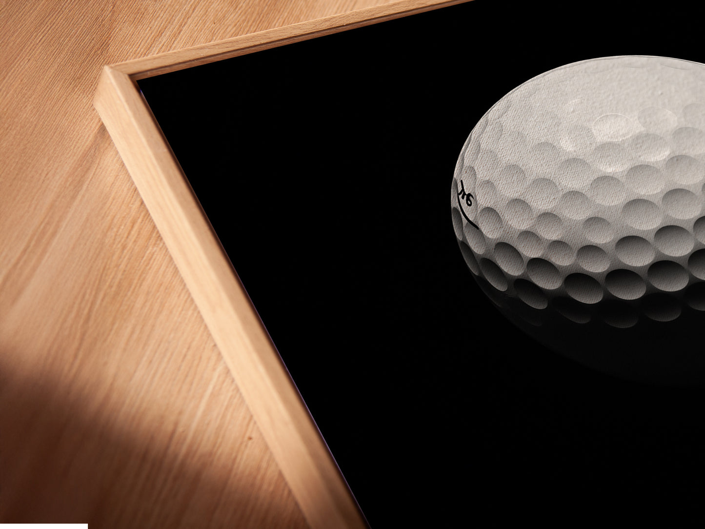 Close up of canvas print in a floating frame. This modern sports art is a great addition to any space. The golf ball print is perfect for golf lovers. The black and red colors add a touch of sophistication.