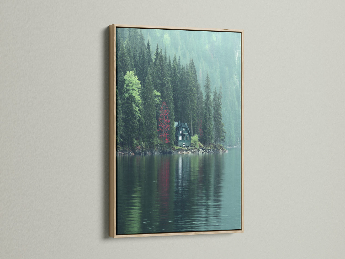 The lakeside cabin artwork is displayed with an oak frame. The artwork captures a tranquil scene of a cabin by a lake and forest. Green and red hues create a moody yet calming nature print. Ideal forest wall art for living rooms or offices seeking a Scandinavian style.
