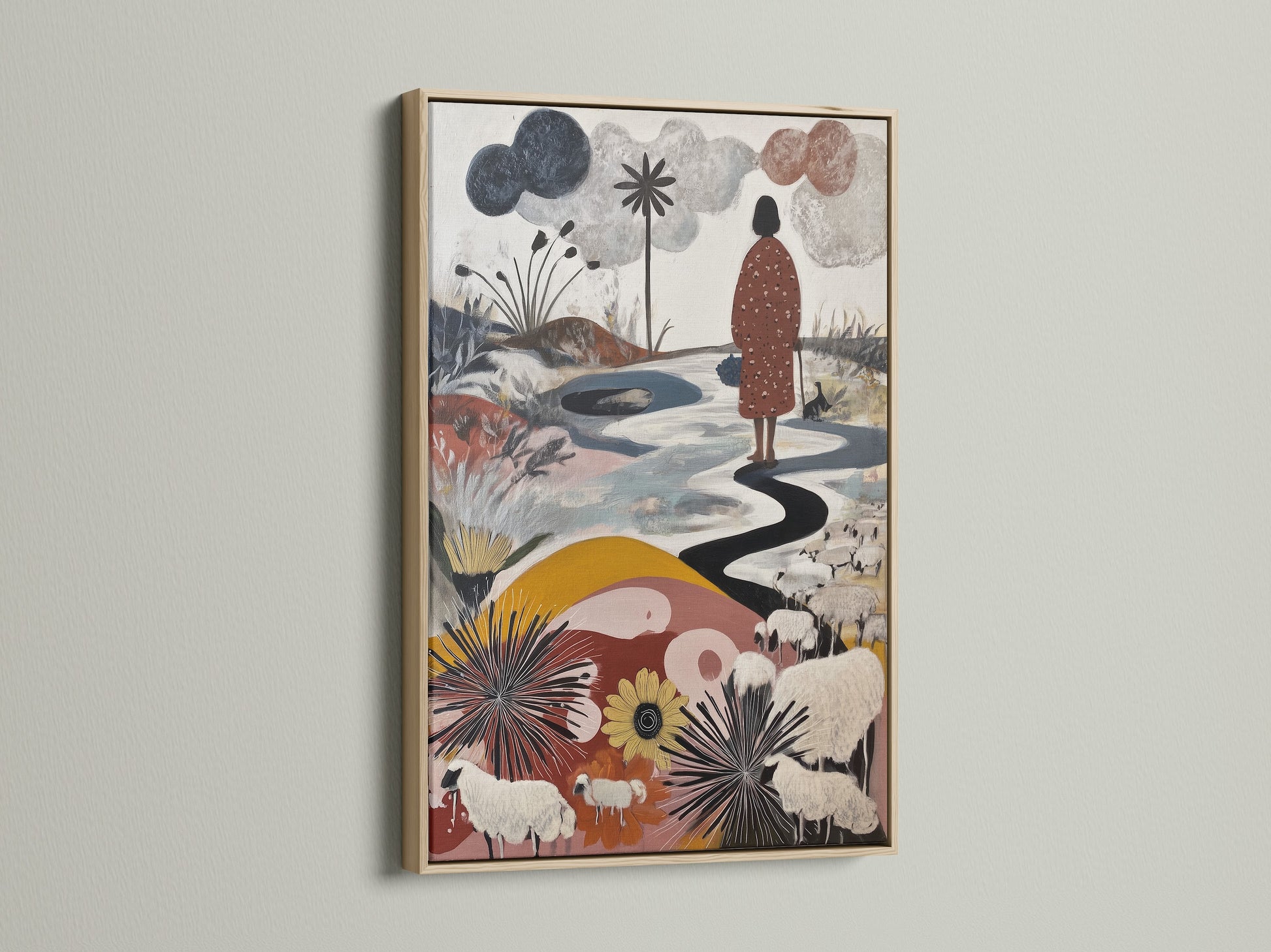 Artwork with an oak frame on a white wall. The artwork features a figure walking along a winding path. Sheep graze in a field of flowers. The oak frame enhances the artwork's natural beauty. Consider our oak frame option.