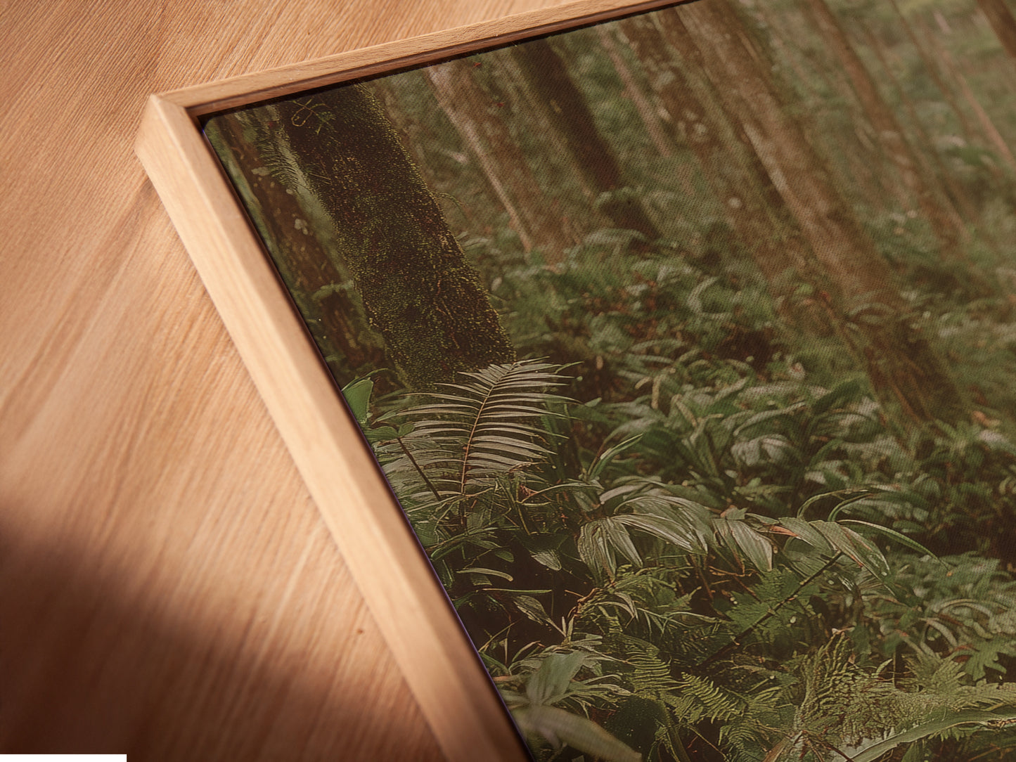 Angled close-up of a canvas print in a floating frame. The artwork features a serene frog pond scene. The botanical forest wall art enhances any space. This nature photography print is perfect for a study room. The floating frame gives the artwork a modern touch. The green frogs and lush forest create a peaceful atmosphere.