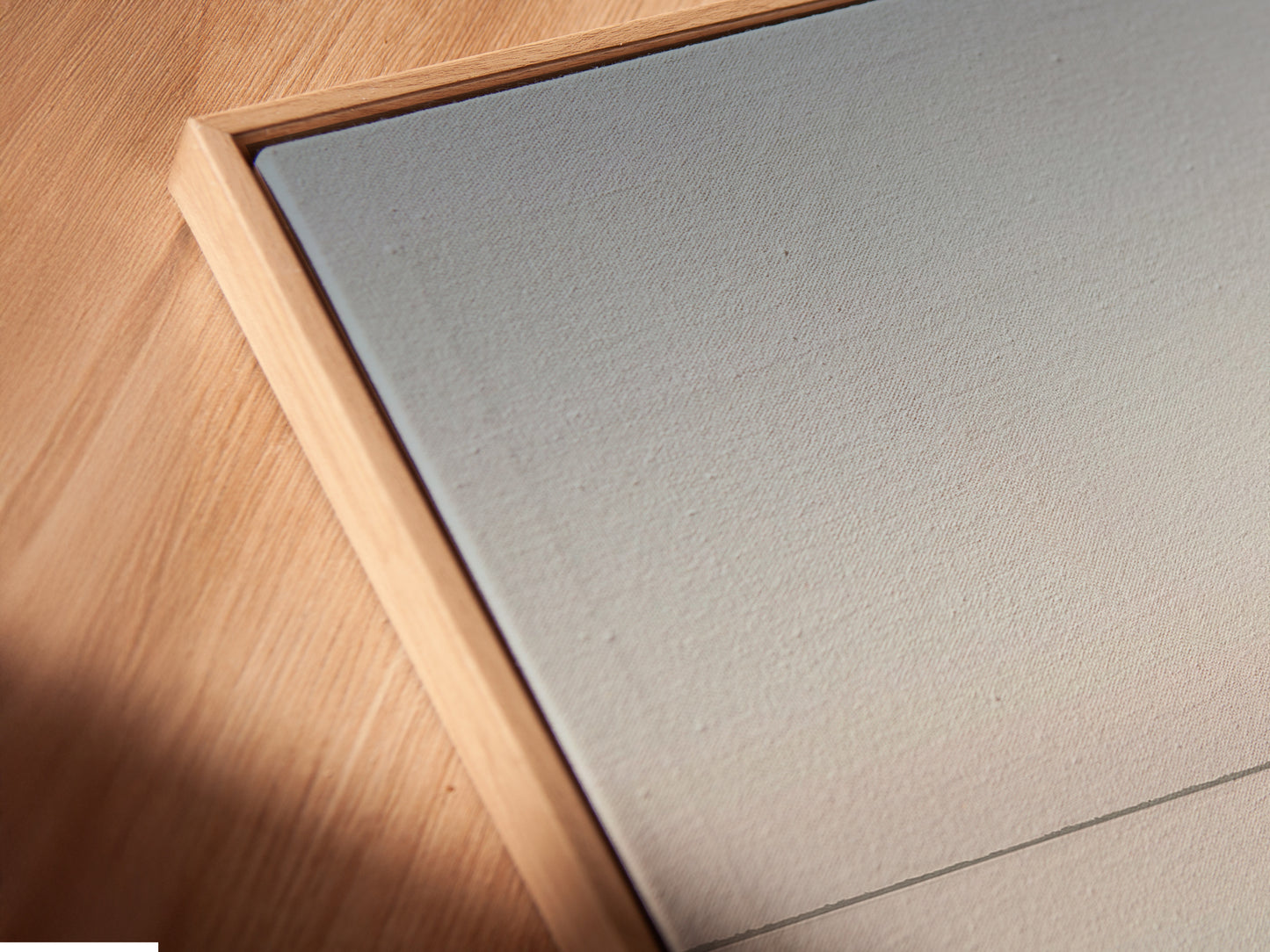 Close-up of a canvas print in a floating frame. This modern framing style gives the artwork a clean and contemporary look. The floating frame enhances the minimalist aesthetic of the coastal canvas. A beautiful display.