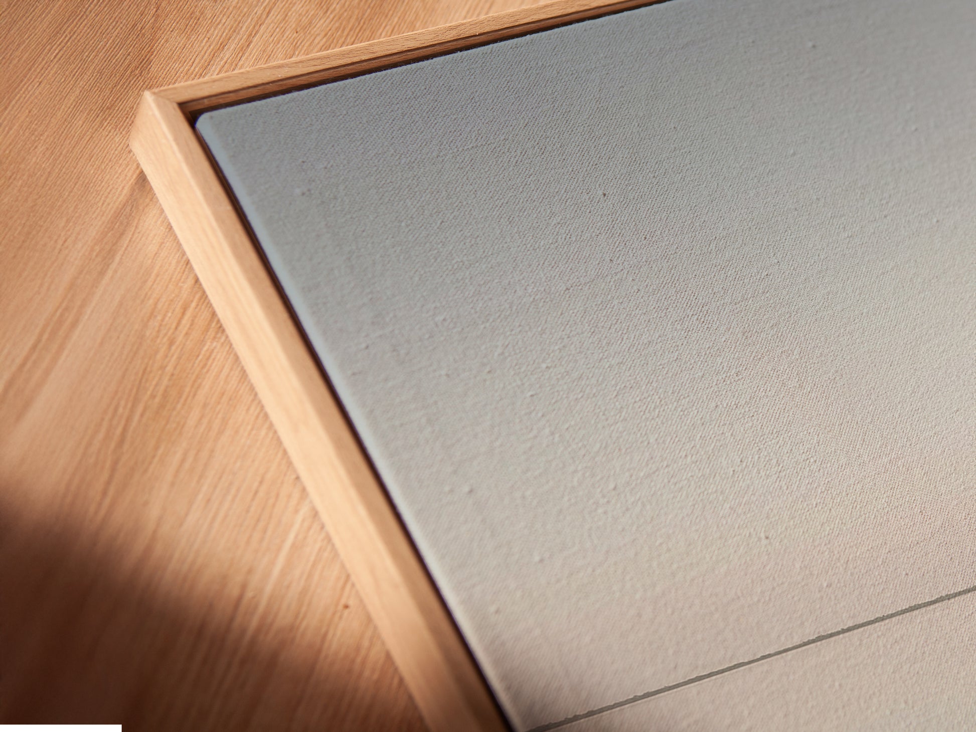 Close-up of a canvas print in a floating frame. This modern framing style gives the artwork a clean and contemporary look. The floating frame enhances the minimalist aesthetic of the coastal canvas. A beautiful display.