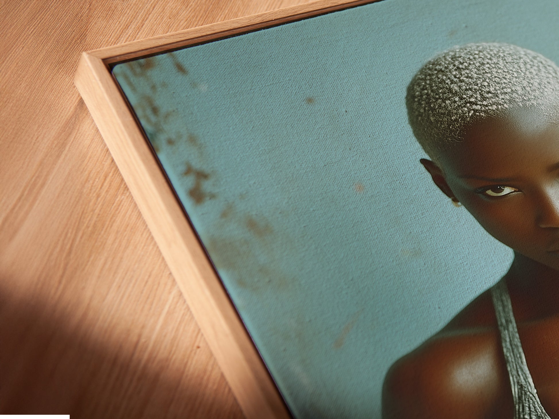 Angled close up of a canvas print in a floating frame. The strong woman fitness art provides gym motivation. Ideal for home gym decor or a workout room. This weightlifting art piece features contemporary style with grey and blue tones.