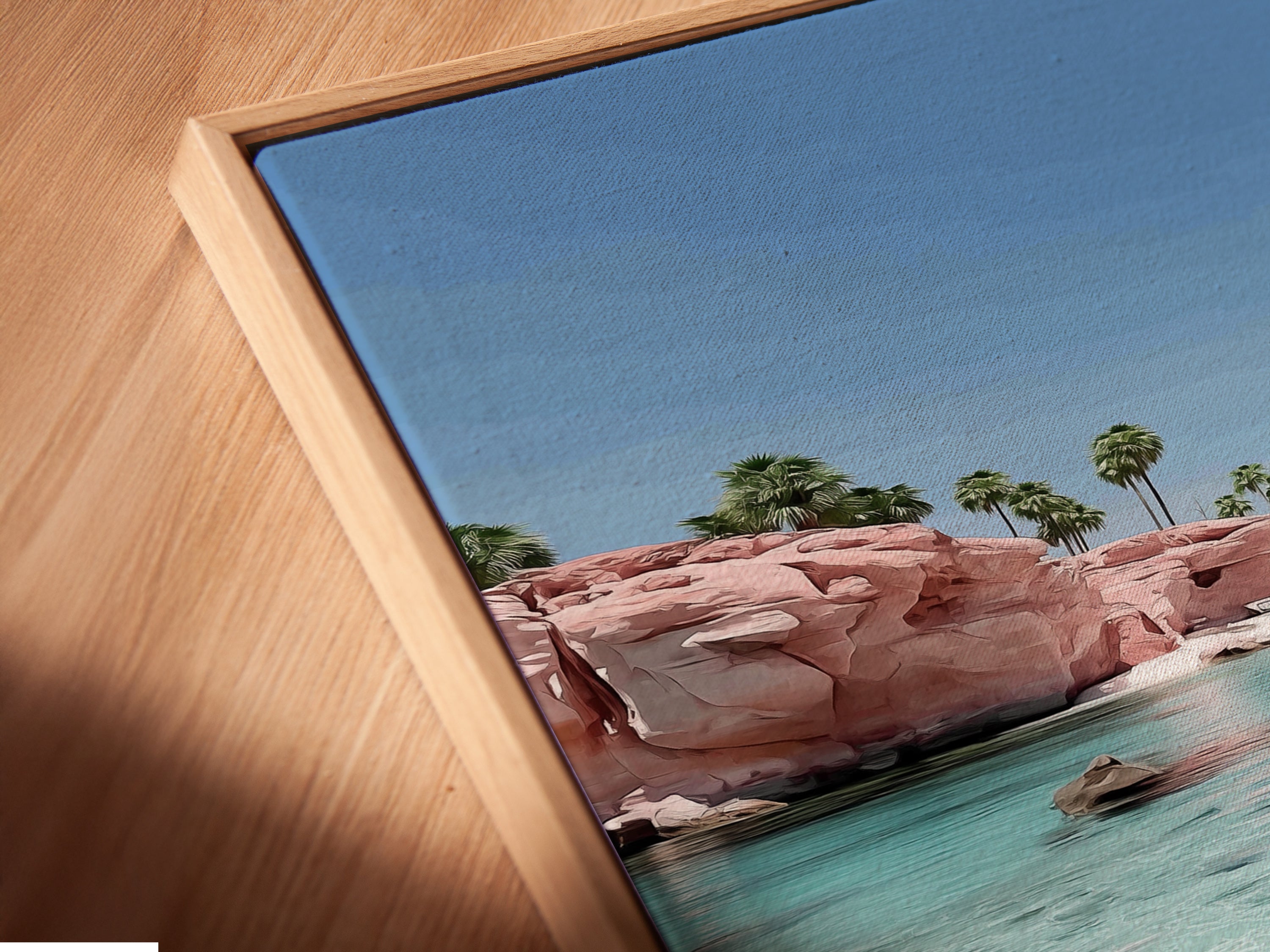 A close up of a canvas print. This canvas print features a pink sand beach in a floating frame. The floating frame gives the artwork a modern look. Perfect for a coastal or beach-themed room.