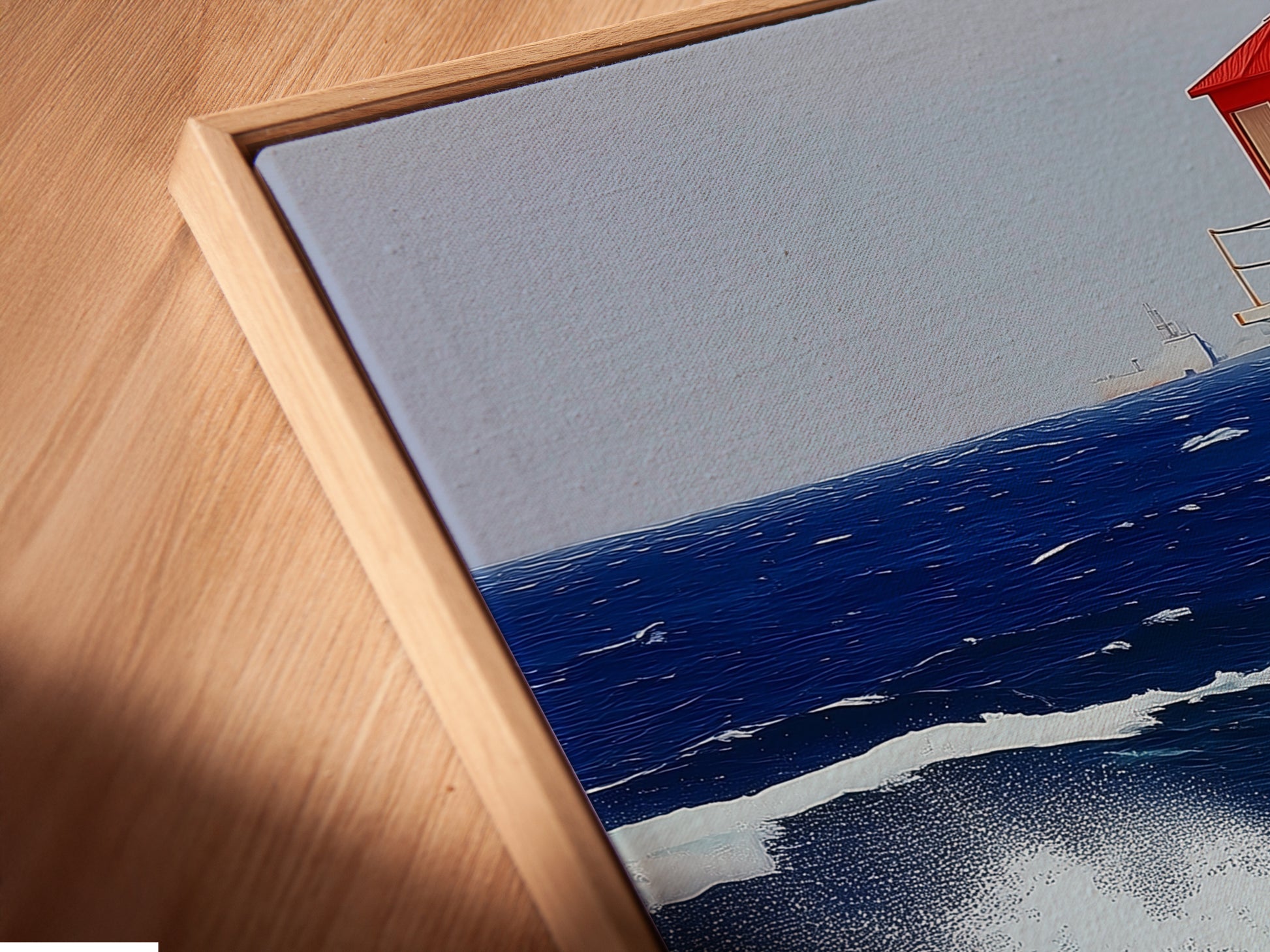 Close-up of a lighthouse canvas print in a floating frame. This modern presentation enhances the artwork. The floating frame creates a sleek sophisticated look. It is perfect for coastal and contemporary interiors. Nautical wall art.