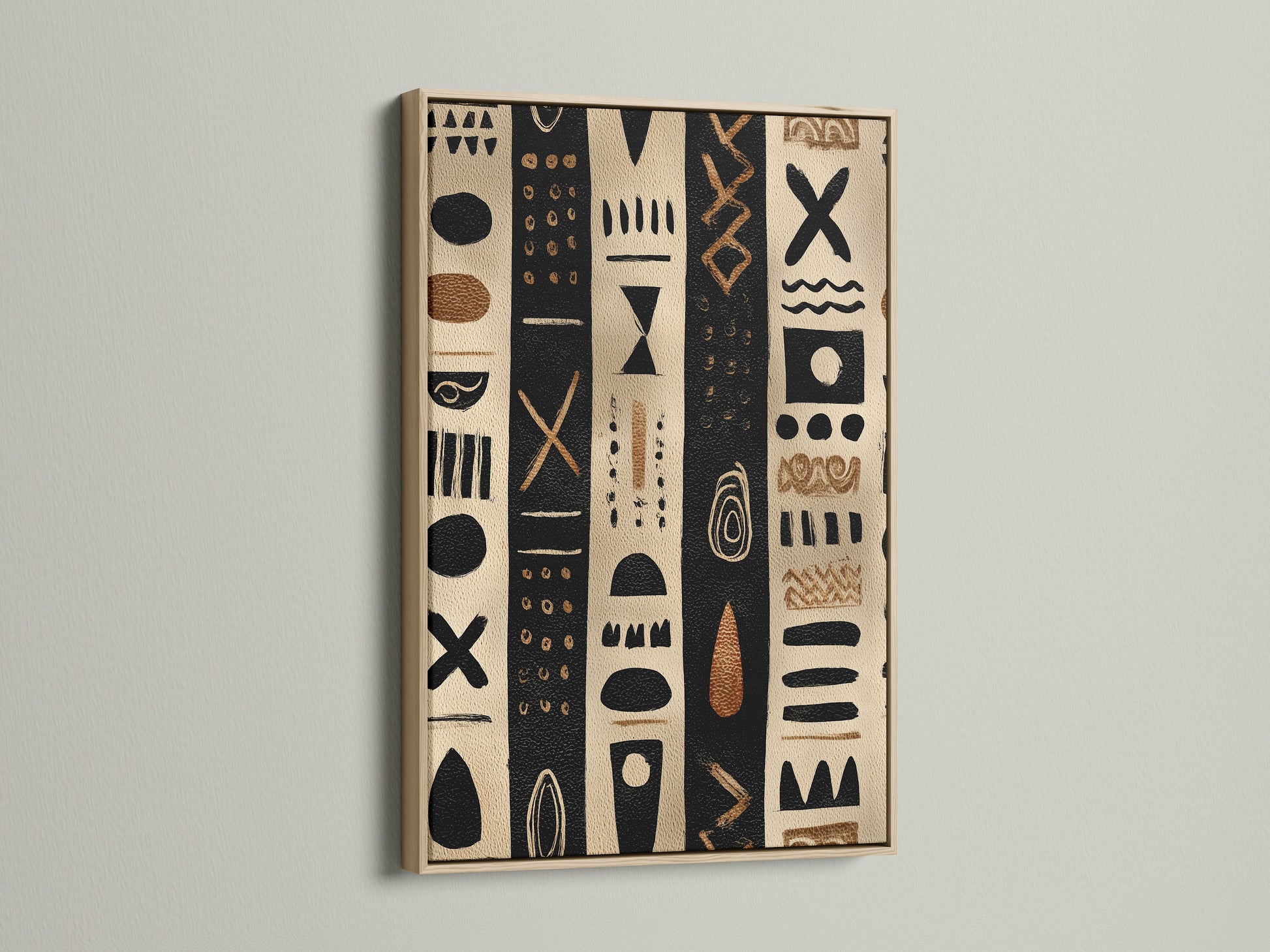 Artwork in an oak frame. The artwork has black and tan stripes with tribal inspired shapes. The artwork is hanging on a white wall. The light reflects off the glass. This artwork is perfect for modern minimalist homes.