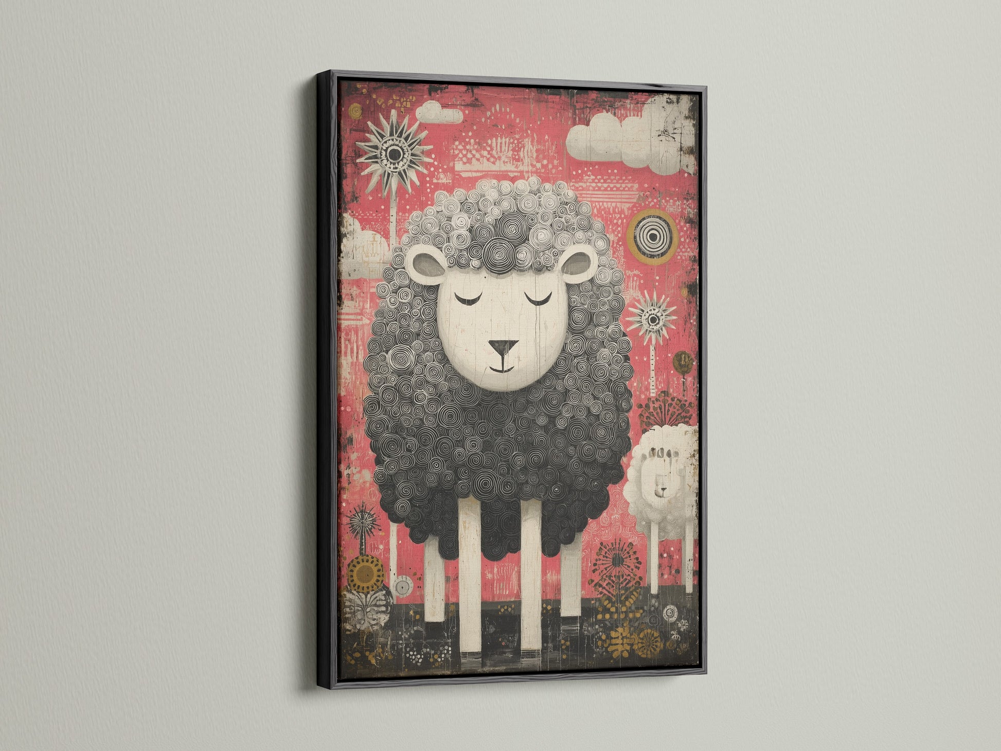 Black frame showcases a cute sheep artwork. The artwork features a black and white sheep. The sheep is set against a pink backdrop. Clouds and suns decorate the background. The black frame adds a touch of sophistication.