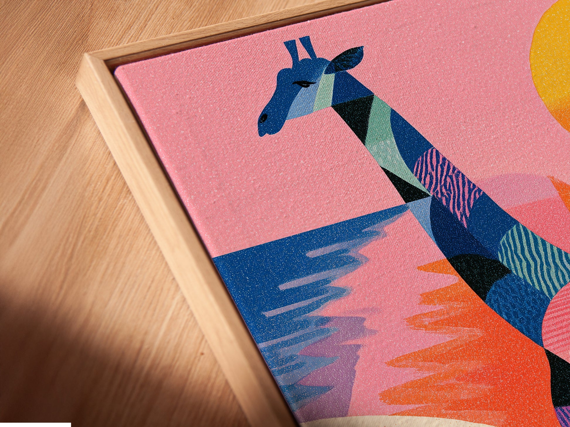A close-up angled view of a canvas print. It is displayed in a floating frame. This modern frame style is sleek. The artwork features a giraffe a bird and a sunset.