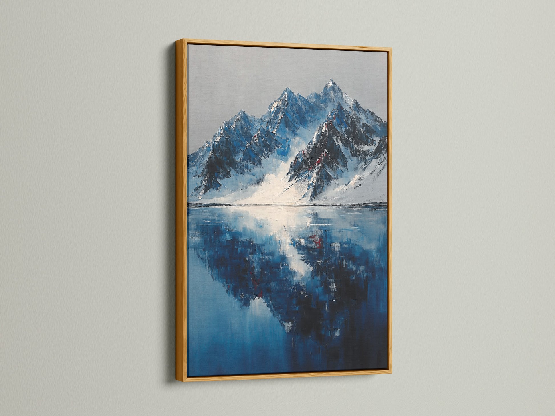 Gold frame holding mountain reflection artwork. This indigo lake canvas adds a luxurious winter landscape to office decor. The gold frame enhances the modern blue art print. It provides a striking winter decor piece. A great snowy mountains painting.