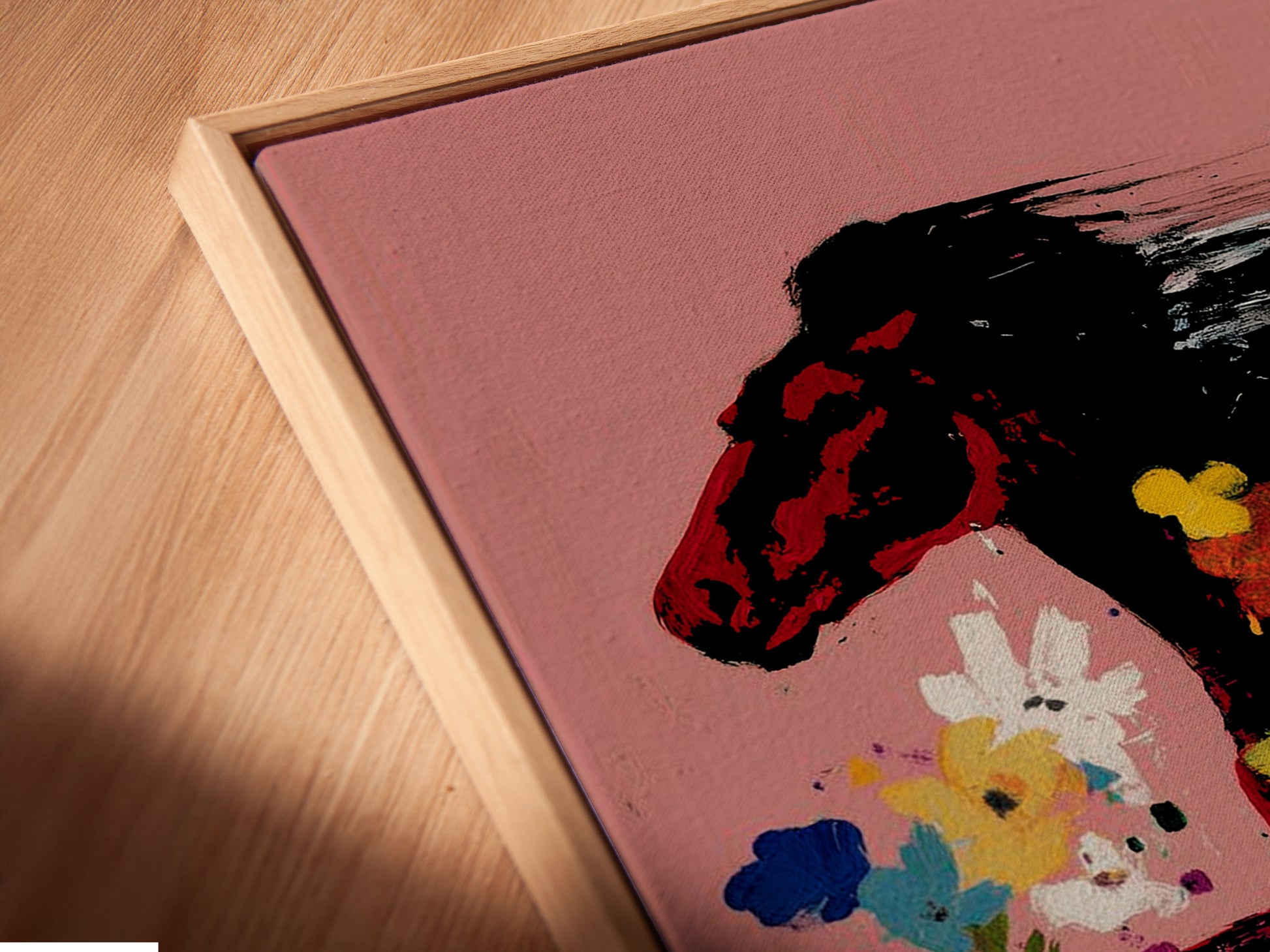 A close-up angled view of a canvas print in a floating frame. The Wild Horse Canvas Art features a beautiful floral abstract animal print. This piece of equestrian decor is perfect for adding a touch of boho style to your home. Its a unique and captivating addition.
