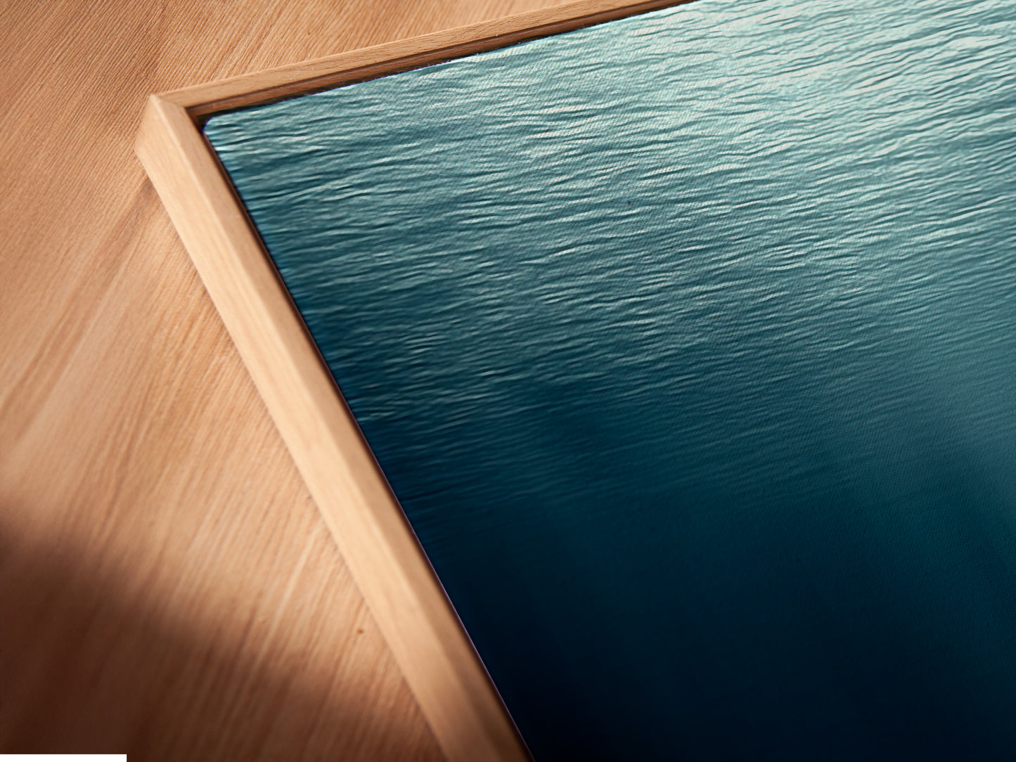 This is a close-up angled view of a canvas print in a floating frame. The artwork features an underwater figure. It's a modern piece perfect for any room. The floating frame adds an elegant touch. This canvas print is a great addition to your wall art collection.