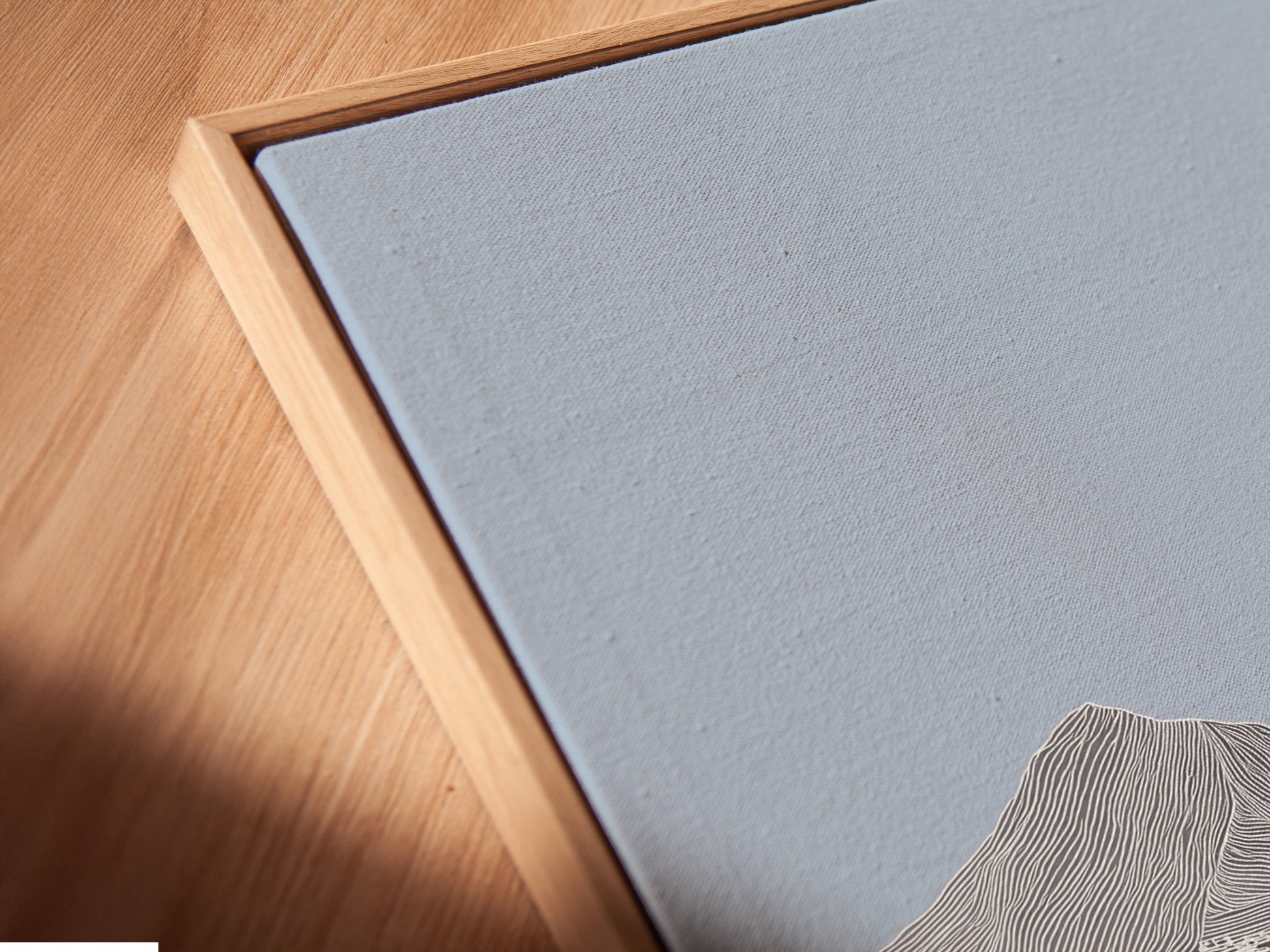 A close-up shows a canvas print in a floating frame. The floating frame gives the artwork a modern look. The angled view highlights the canvas texture. See how the frame enhances the art's depth. This style adds sophistication to any space. Explore our floating frame options today.