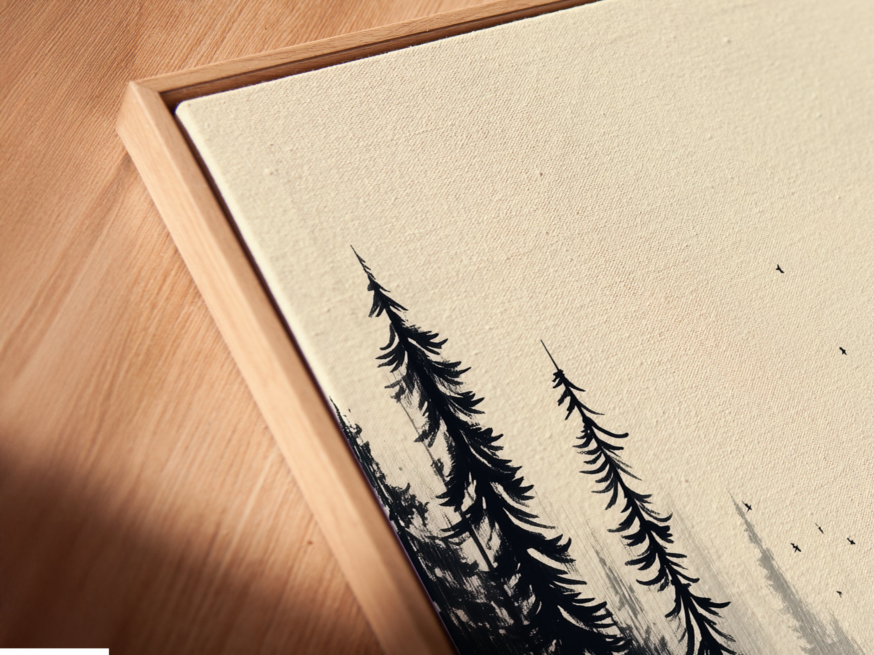 A close up angled view of a canvas print in a floating frame. The forest artwork features a monochrome forest scene. Notice how the frame enhances the misty woodland wall art. Perfect as nature artwork for a bedroom or living room. This minimalist art complements a Scandinavian interior.