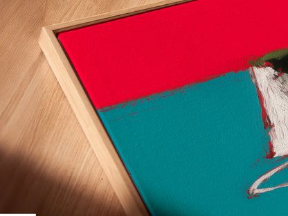Angled close-up of a coastal road canvas print in a floating frame. The artwork features a red car on a scenic route. The floating frame enhances the modern aesthetic. Perfect for adding a touch of mid-century charm to your home or office. This is a great piece for car collectors.