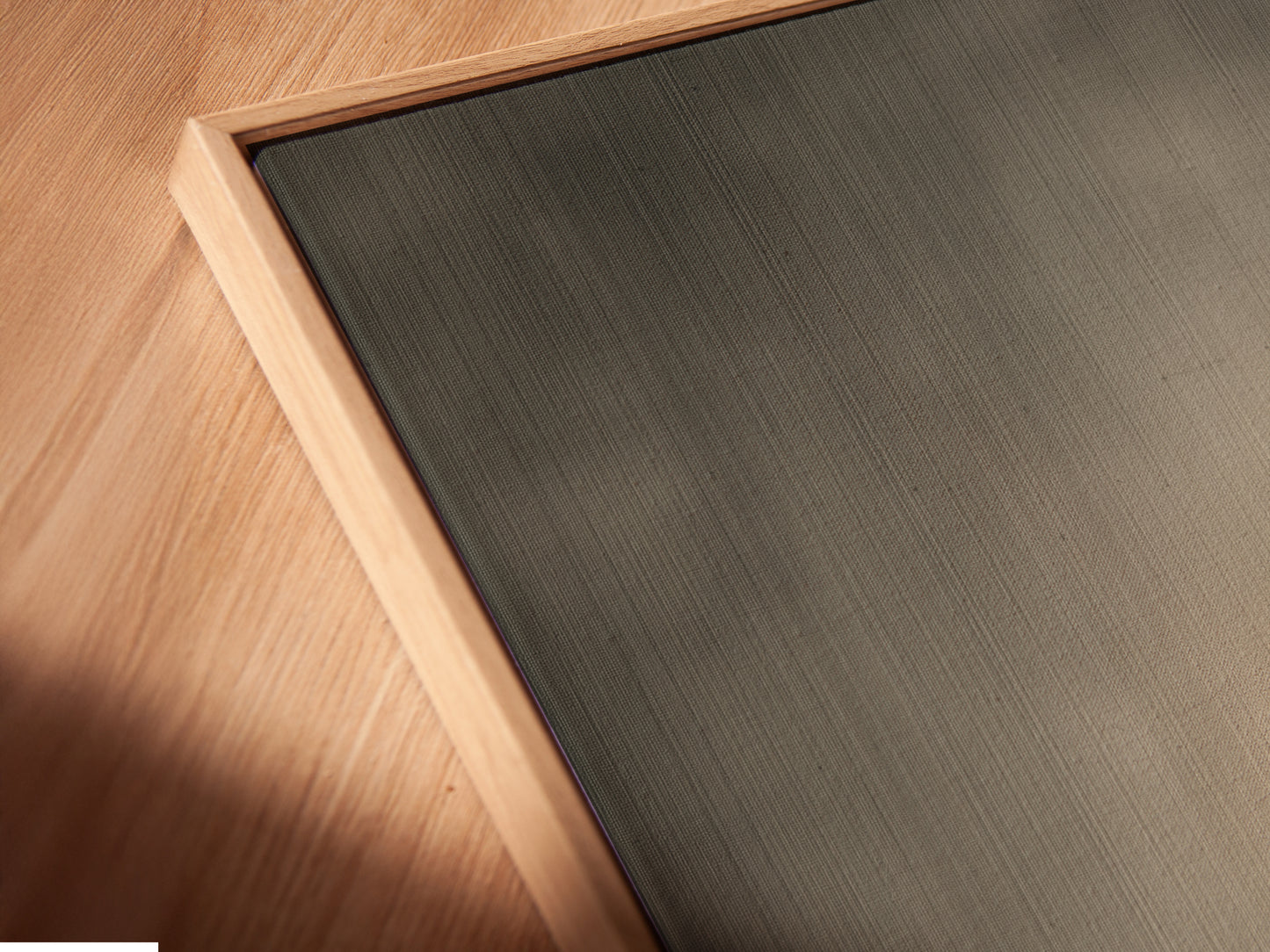 A close-up angled view of a canvas print in a floating frame. The Silhouette Canvas Print adds modern minimalist decor to any space. Perfect as gray wall art for a meditation room.