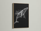 A close up of a black and white whale artwork in an oak frame. The minimalist ocean canvas print enhances modern bedroom decor. Discover the beauty of marine life art. The oak frame provides a natural touch. This whale canvas print is perfect for coastal wall decor.