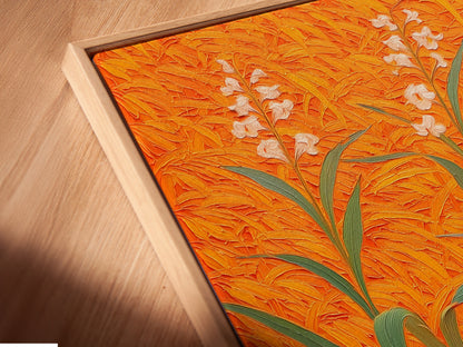 A close-up angled view of a canvas print in a floating frame. The artwork features a floral field with an orange botanical theme. This modern plant artwork is ideal for entryway wall decor. The floating frame adds a contemporary touch. Perfect for living rooms bedrooms and offices.