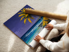 A woman is carefully rolling a fine art poster paper. The paper showcases a beautiful tropical beach artwork. Ideal for homeowners renters and interior decorators. This art captures a coastal paradise.