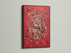 Eye-catching abstract splatter art print on a red canvas. The artwork is elegantly framed in black. The use of paint drip art adds a modern touch. Perfect for contemporary spaces. This bold red art makes a statement in any room. Ideal for modern art enthusiasts.
