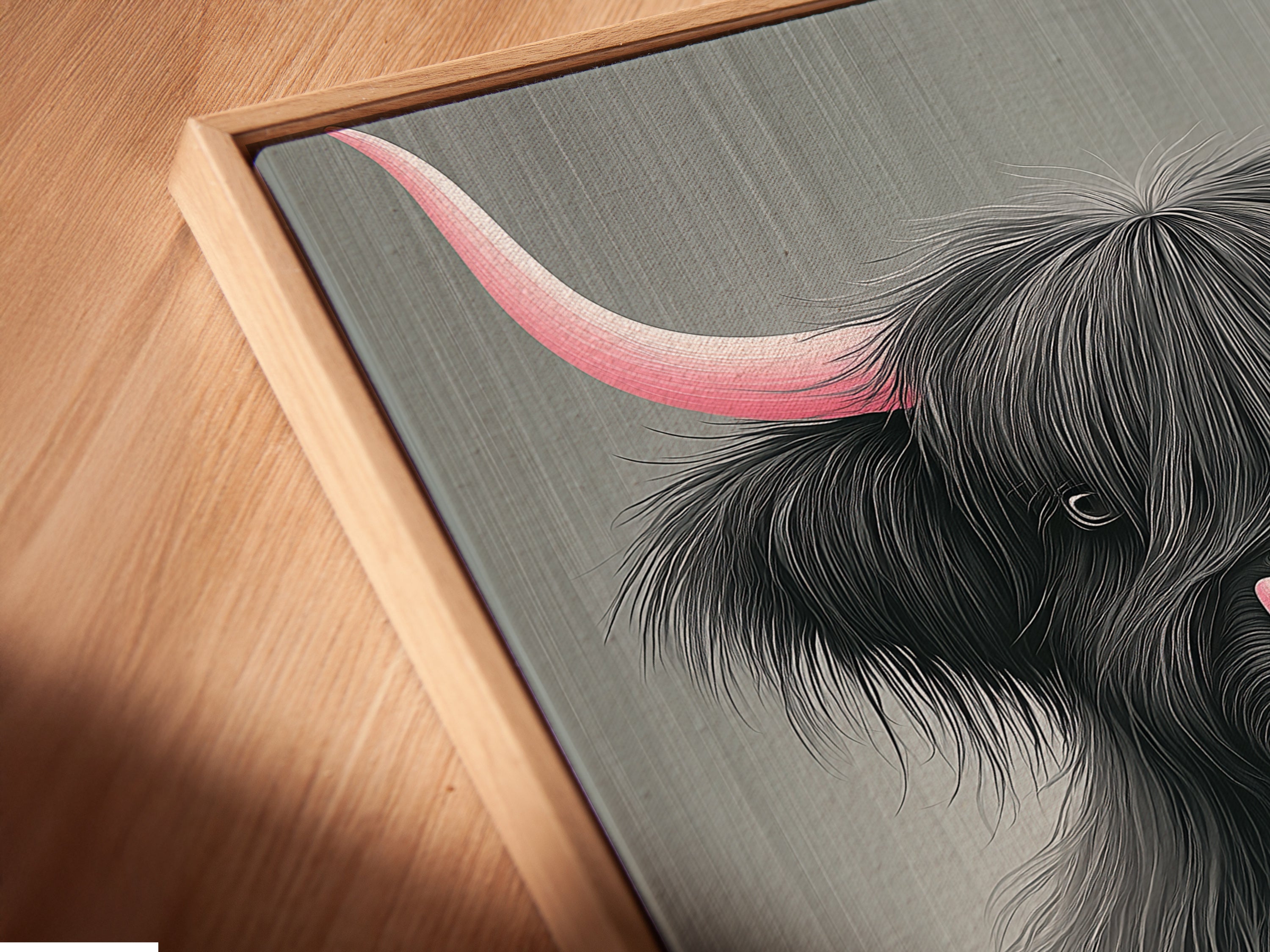 Close up of a canvas print in a floating frame. The Highland Cow artwork with pink horns is beautifully displayed. The floating frame adds depth and dimension to the piece. Perfect for modern farmhouse decor. This cow canvas print elevates any space.