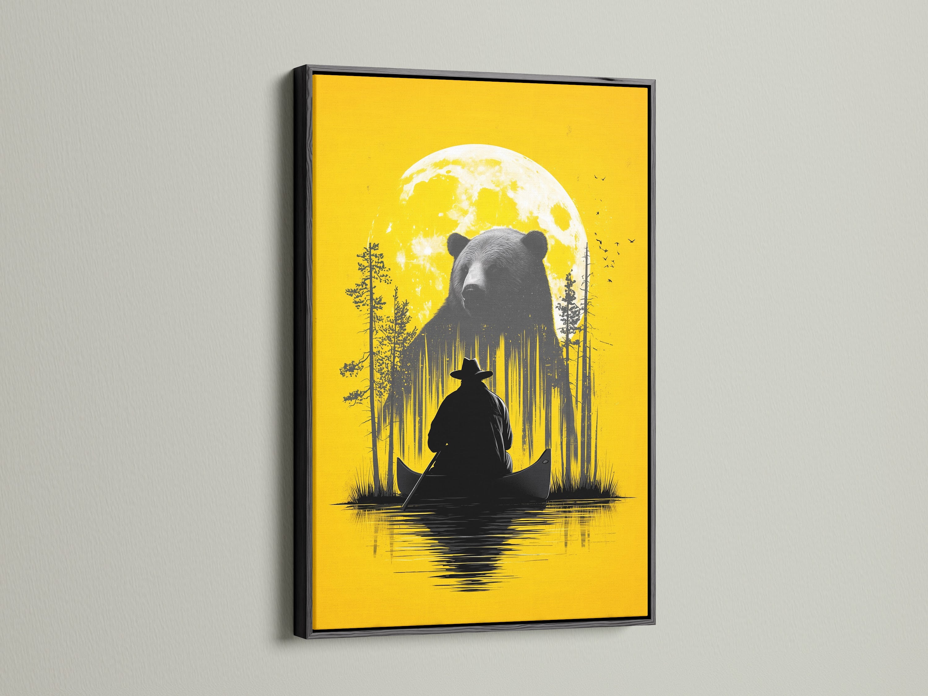 Framed Bear and Canoe artwork is displayed. The frame is a black frame. It is a rustic nature wall art. It shows a bear and a canoe under a yellow moon. Ideal for cabin decor and adventure art lovers. The black frame adds a touch of sophistication. It enhances the contrast of the artwork.