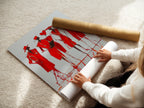 A woman carefully rolls a fine art poster paper. The paper showcases Red Fashion Sketch Art. This contemporary figure drawing is perfect for creating stylish wall art. Great for posters.
