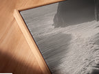 Here is a close-up of a canvas print in a floating frame. The black and white ocean waves artwork is displayed beautifully. The floating frame enhances its contemporary appeal. Ideal for modern coastal decor in any living space. This aerial beach photography captures the ocean's serene beauty. A perfect addition to elevate your home decor today.