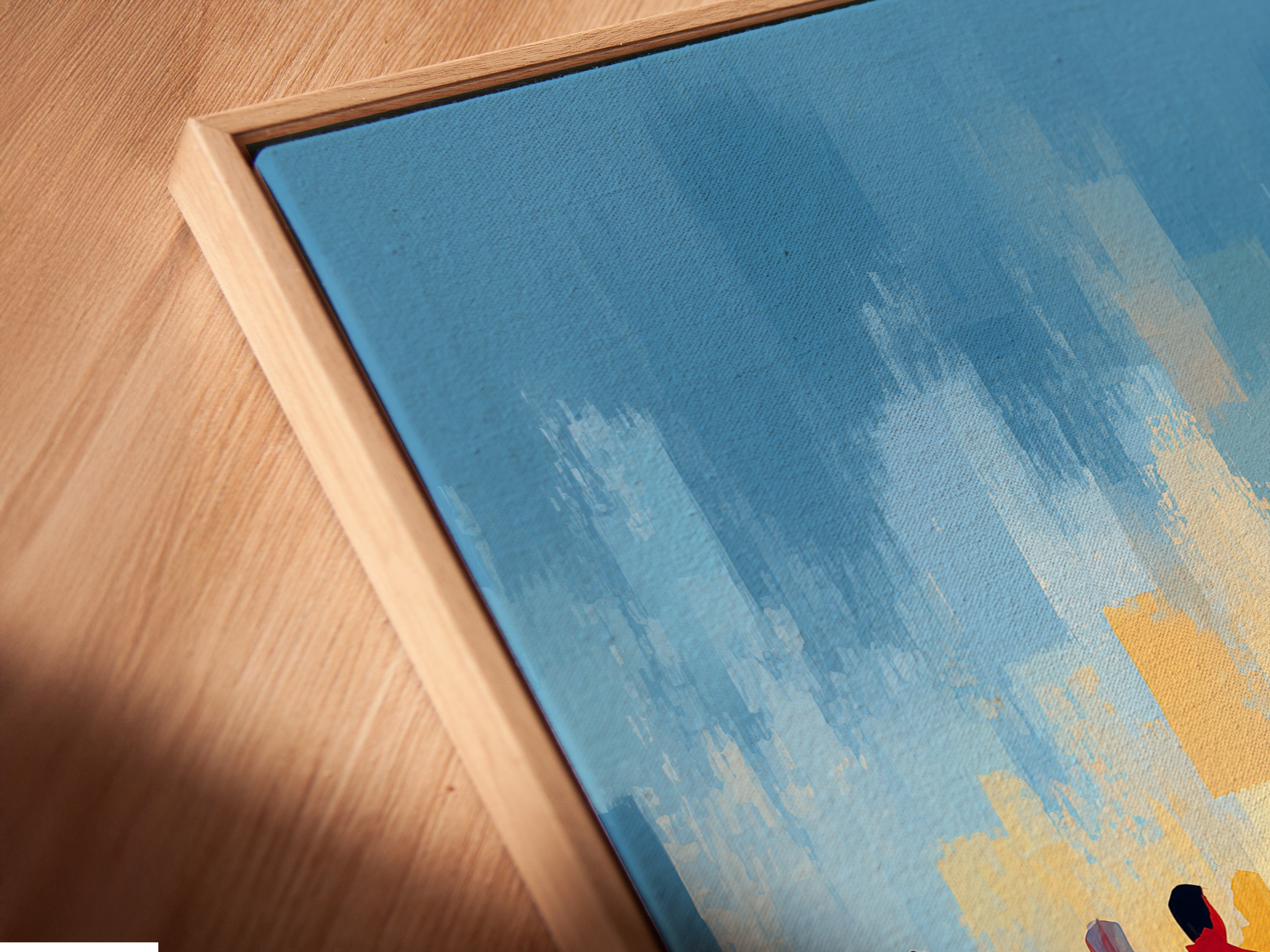 Close-up angled view of a canvas print in a floating frame. The abstract sports wall art features marathon runners in blue and orange. Perfect for adding a modern touch to any space. Ideal for fitness enthusiasts seeking motivational decor. Elevate your walls today.