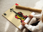 A woman rolls fine art poster paper. It is for a violin art print. The abstract musical instrument artwork is perfect for music enthusiasts. This graphic artwork is ideal for music rooms studios and schools. It makes a great gift for musicians and music lovers alike.