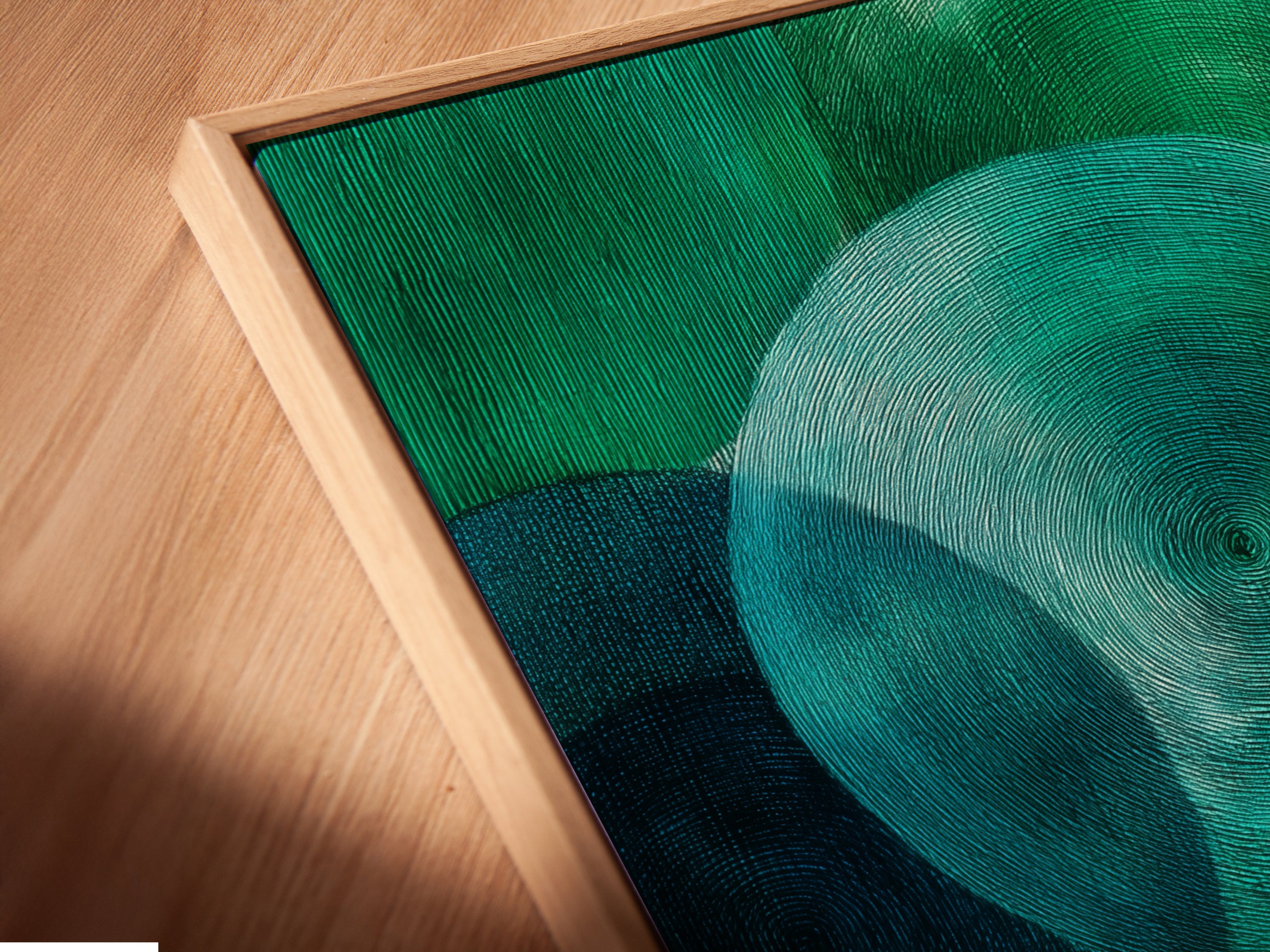 This is an angled close up of a canvas print in a floating frame. The artwork features emerald green circles. This modern textured print is great for office wall decor. Perfect for homeowners renters interior designers and business owners seeking elevated modern art.