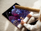 A woman is carefully rolling a fine art poster paper. The Floral Night artwork in indigo and violet is ready for framing. This botanical print adds a touch of modern elegance. Perfect for enhancing bedroom wall decor and interior spaces.