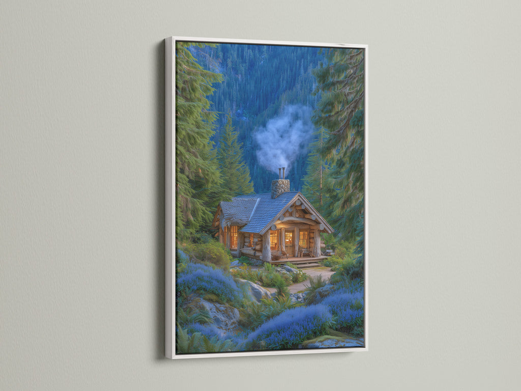 A framed forest cabin artwork with a white frame is displayed. The artwork features a cozy mountain lodge nestled among pine trees and blue flowers. This rustic woodland cottage art brings nature indoors. The white frame offers a clean and modern look complementing any interior.
