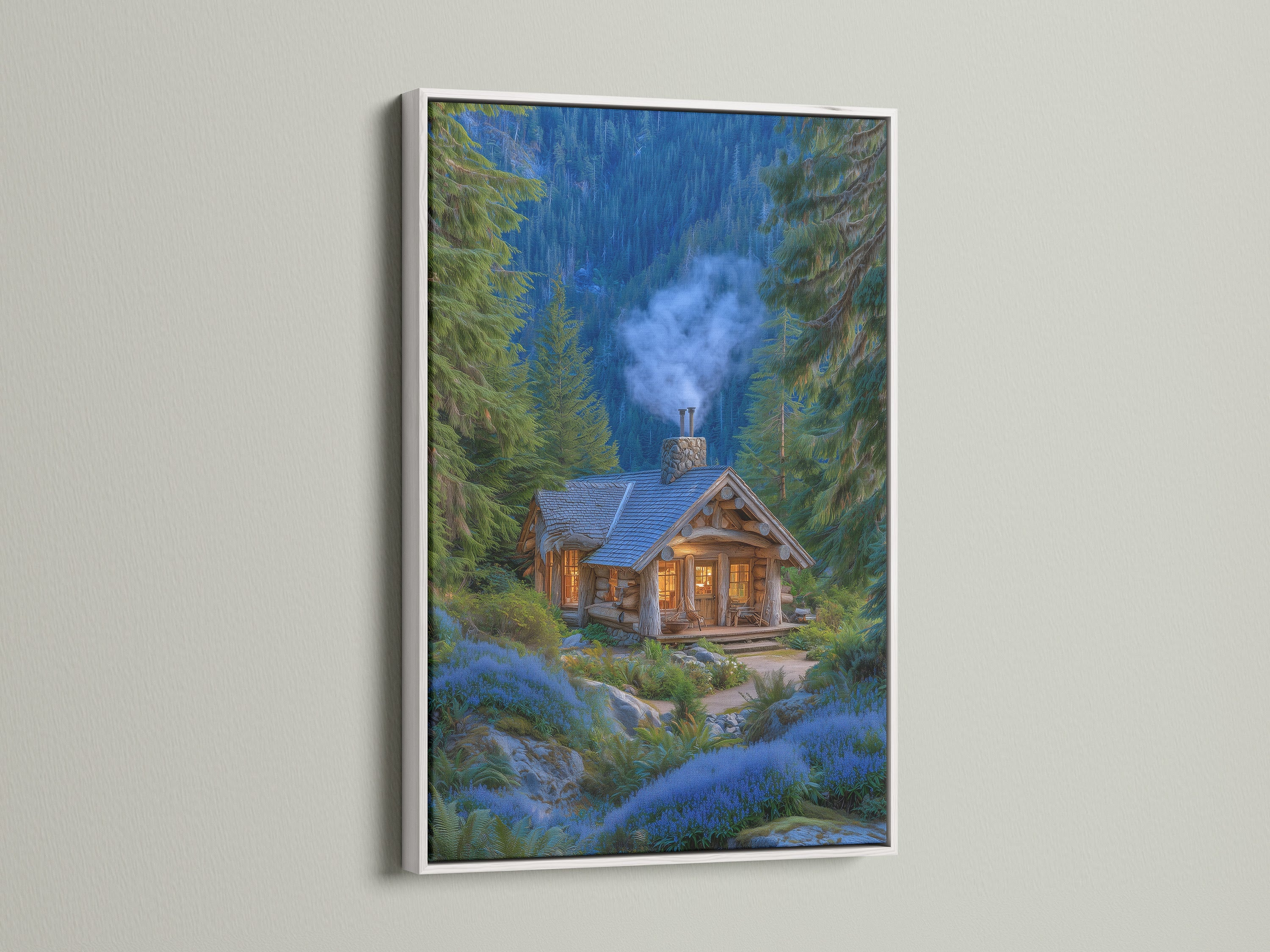 A framed forest cabin artwork with a white frame is displayed. The artwork features a cozy mountain lodge nestled among pine trees and blue flowers. This rustic woodland cottage art brings nature indoors. The white frame offers a clean and modern look complementing any interior.
