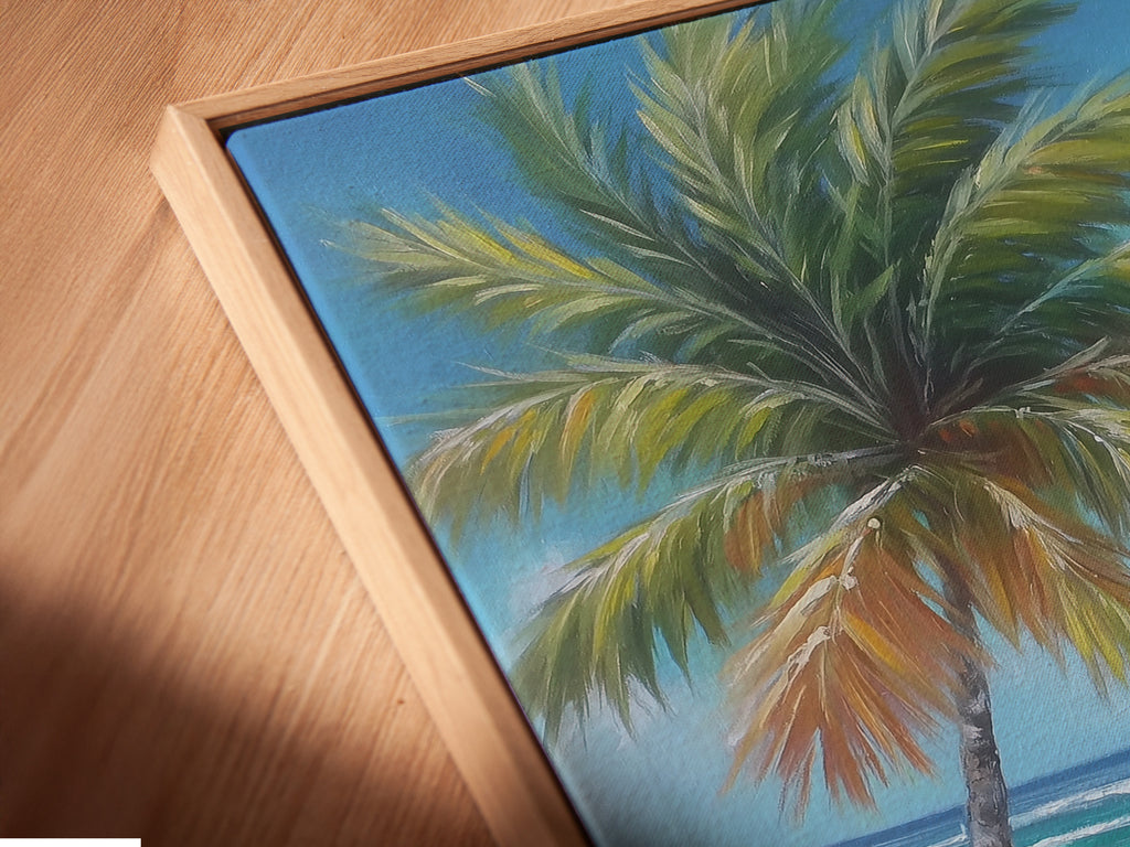 Close-up of a canvas print in a floating frame. The tropical beach artwork features palm tree coastal wall art and a turquoise ocean painting. The artwork captures a soothing coastal vibe perfect for living room wall art. Ready to hang and admire.
