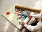 A woman carefully rolling a fine art poster paper. Ensuring the Japanese bird artwork arrives in perfect condition. High-quality materials for stunning vintage botanical art prints.