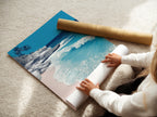 A woman carefully rolling fine art poster paper. Preparing a tropical beach artwork print. Our coastal prints are perfect for any decor style. High-quality materials ensure lasting beauty in every piece. Shop now.