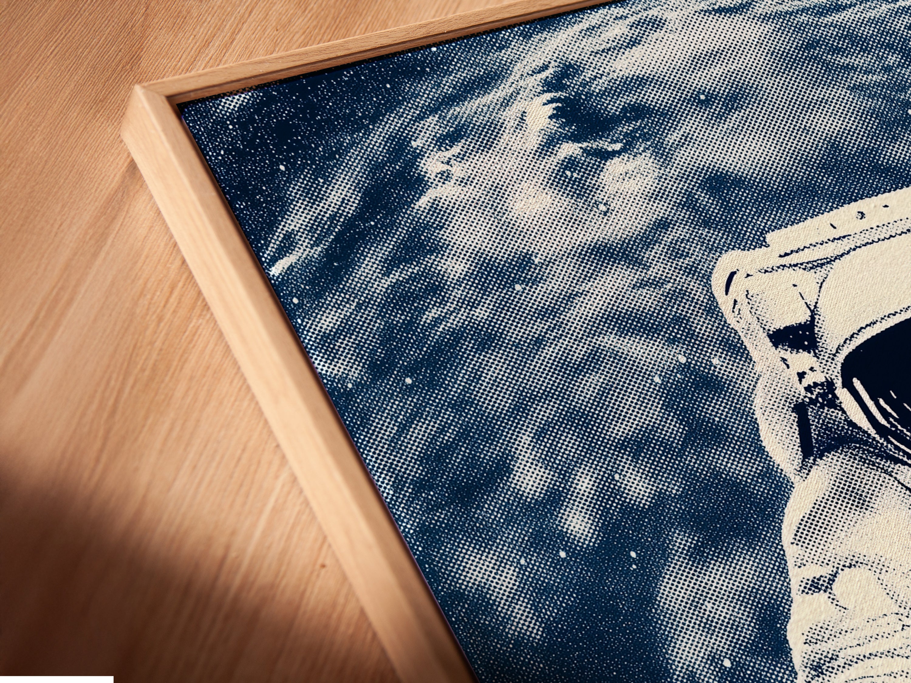 A close-up angled view reveals a canvas print in a floating frame. The astronaut space art is beautifully displayed. This modern art piece is ideal for contemporary minimalist or industrial styles. Elevate your walls with cosmic artwork.