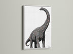 Dinosaur wall art featuring a minimalist brontosaurus canvas print. It is perfect modern nursery decor for a kids room. The artwork has a white frame. This sauropod artwork is great for children's boutiques and pediatric clinics.