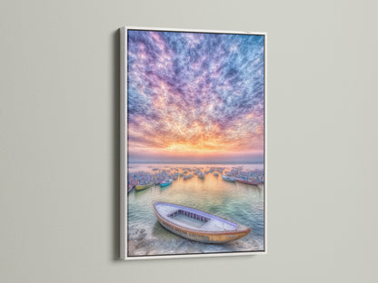 Harbor Sunset art print displayed in a white frame. The coastal artwork showcases fishing boats under a colorful sunset. This seascape canvas art adds a calming touch to any space. The white frame enhances its serene aesthetic. Perfect for creating a tranquil atmosphere in your living room or bedroom.