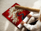 A woman is carefully rolling a fine art poster paper. The cherry blossom tree artwork is being prepared for display. This Japanese bonsai canvas wall art is perfect for adding Asian-inspired decor to your space. The red and gold colors evoke a sense of zen tranquility. Perfect for bedroom wall art.