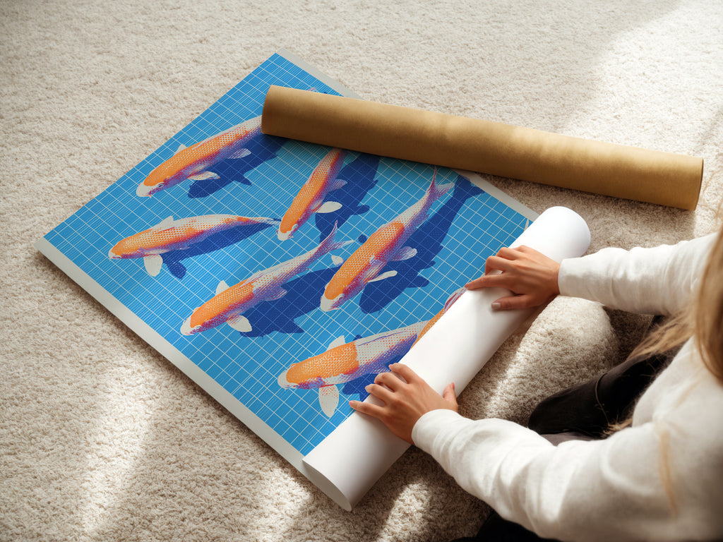 A woman carefully rolling a fine art poster paper featuring Koi Fish art. The blue and orange artwork is ready for framing. This Japanese print is perfect for modern wall decor. Ideal for adding a touch of zen to your living space.