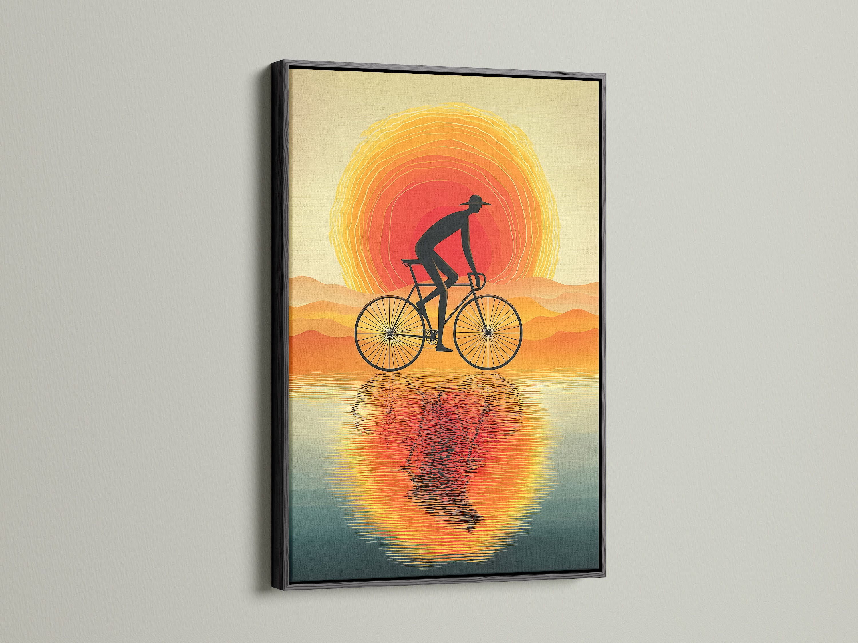 View the Sunset Ride cyclist canvas in a black frame. The dark frame emphasizes the silhouette print. A modern home art piece that complements minimalist decor. This is ideal for man caves and studios.