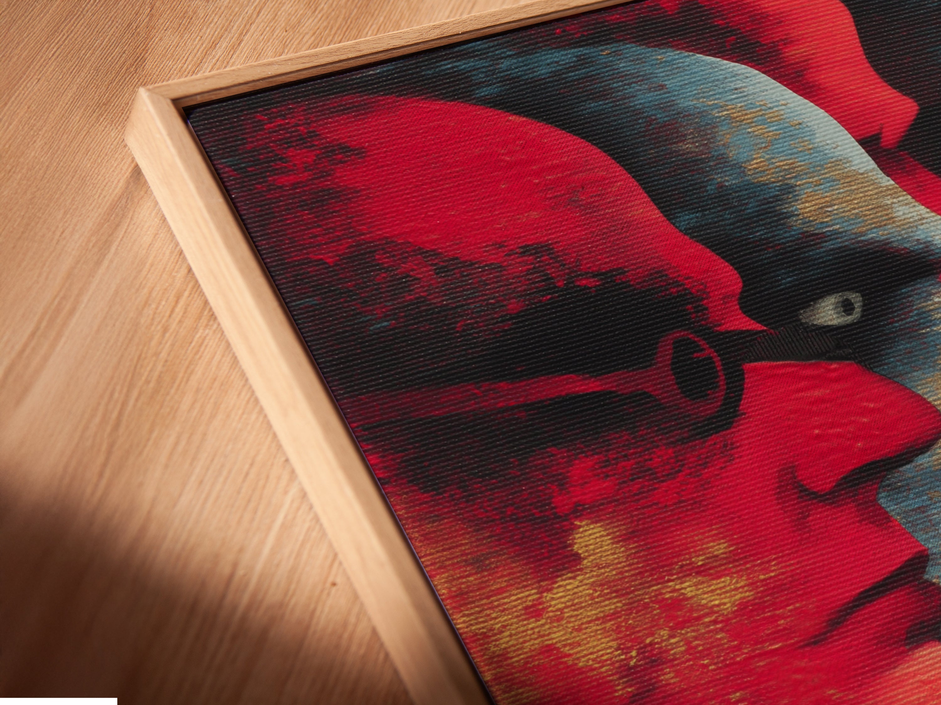 A close-up angled view of an abstract faces canvas print in a floating frame. The red and blue hues create a modern portrait. This unique artwork adds a touch of elegance to any space. Perfect for homeowners or renters looking for contemporary wall decor. Enhance your living room bedroom or office with this bold art print.